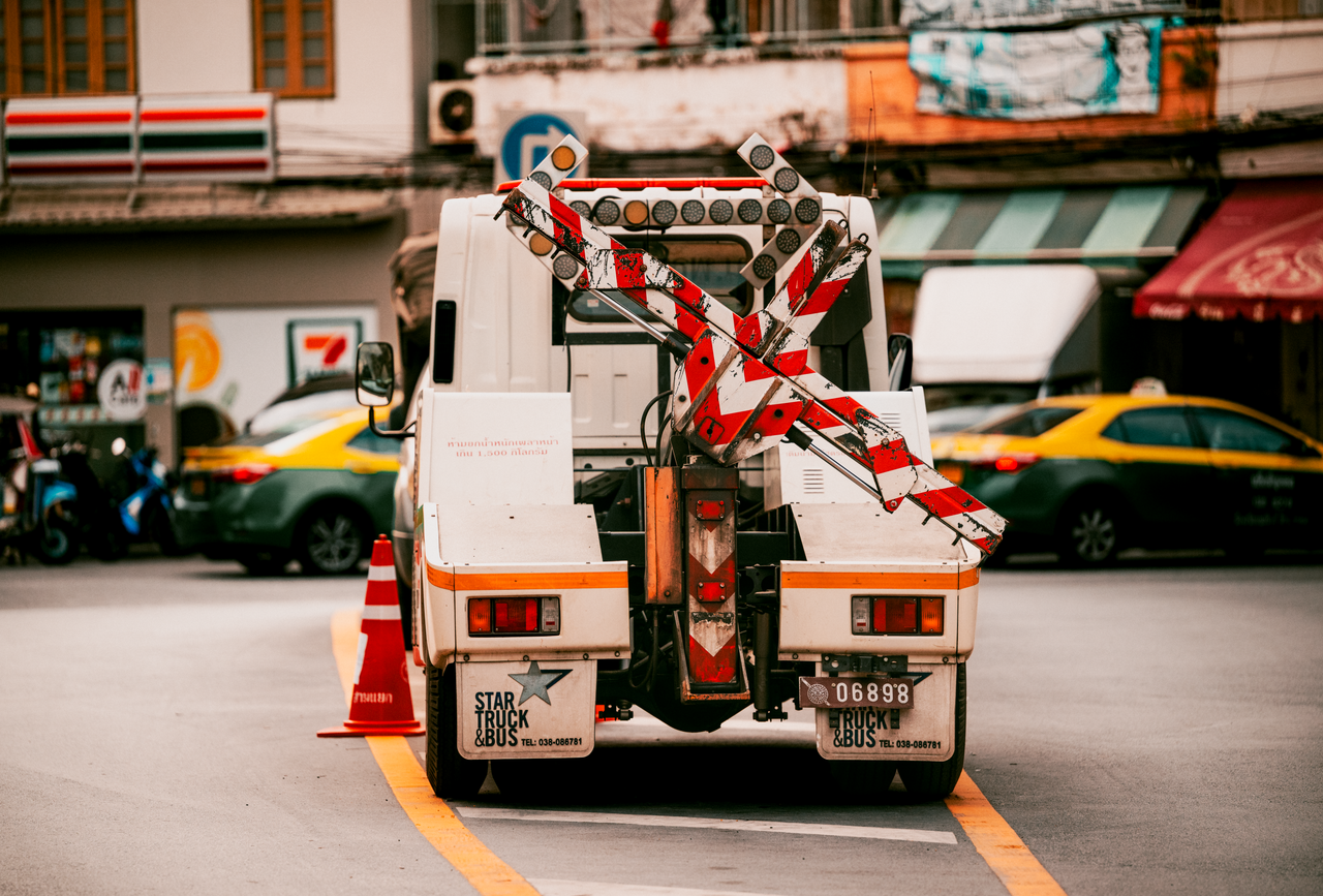 Utility vehicle with traffic barriers on a busy street in Bangkok, Thailand.